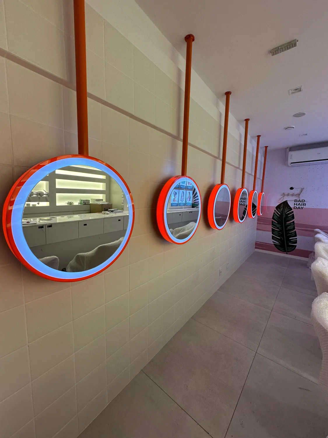 Franquia Blow: corredor de espelhos redondos com iluminação e bancada contínua