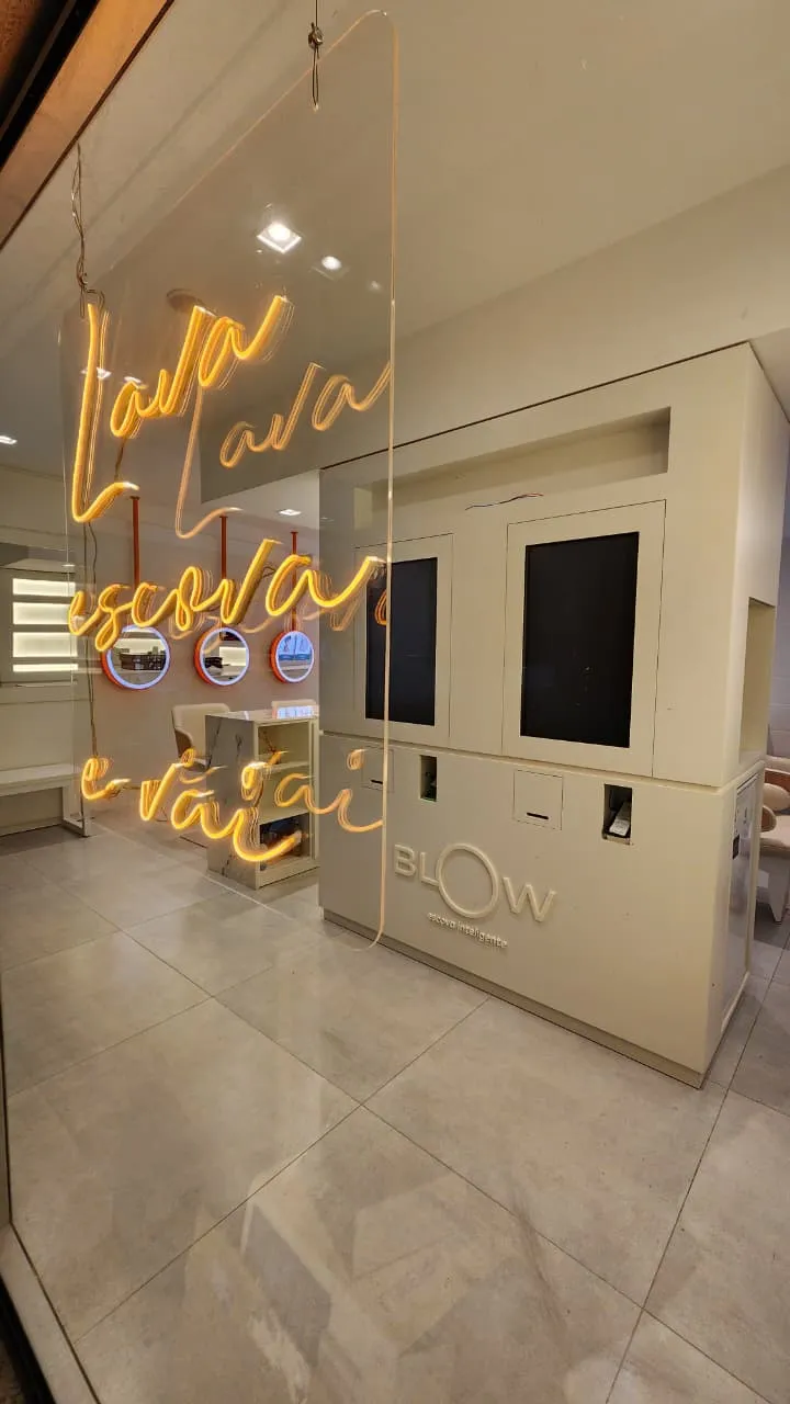 Franquia Blow: recepção com letreiro em neon sobre vidro