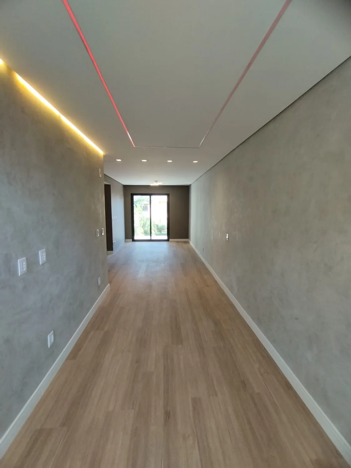 Reforma Residencial 357: corredor com piso de madeira e luz natural