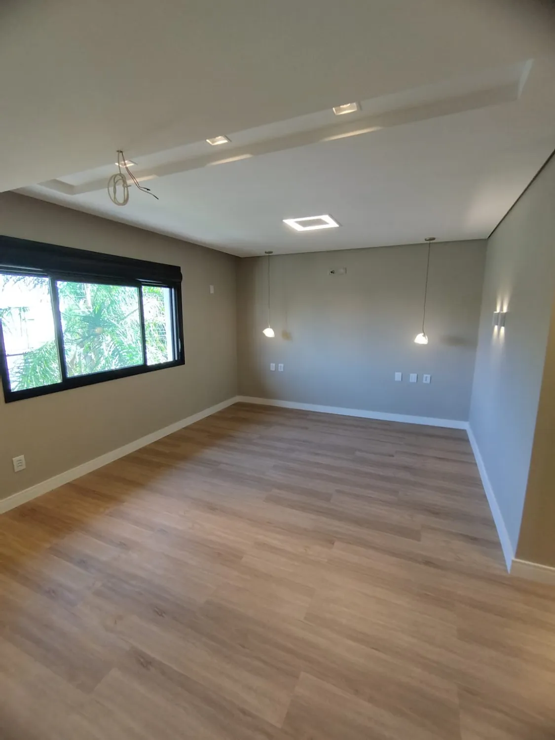Reforma Residencial 357: quarto com piso de madeira e janela ampla