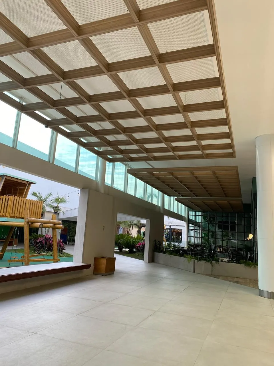 Shopping Gravataí: átrio com forro de madeira, claraboia e piso de porcelanato
